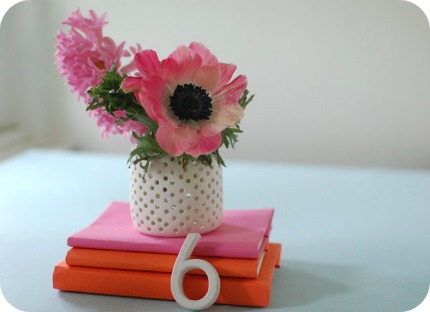  on wrapping books in paper adds a pop of color to wedding centerpieces